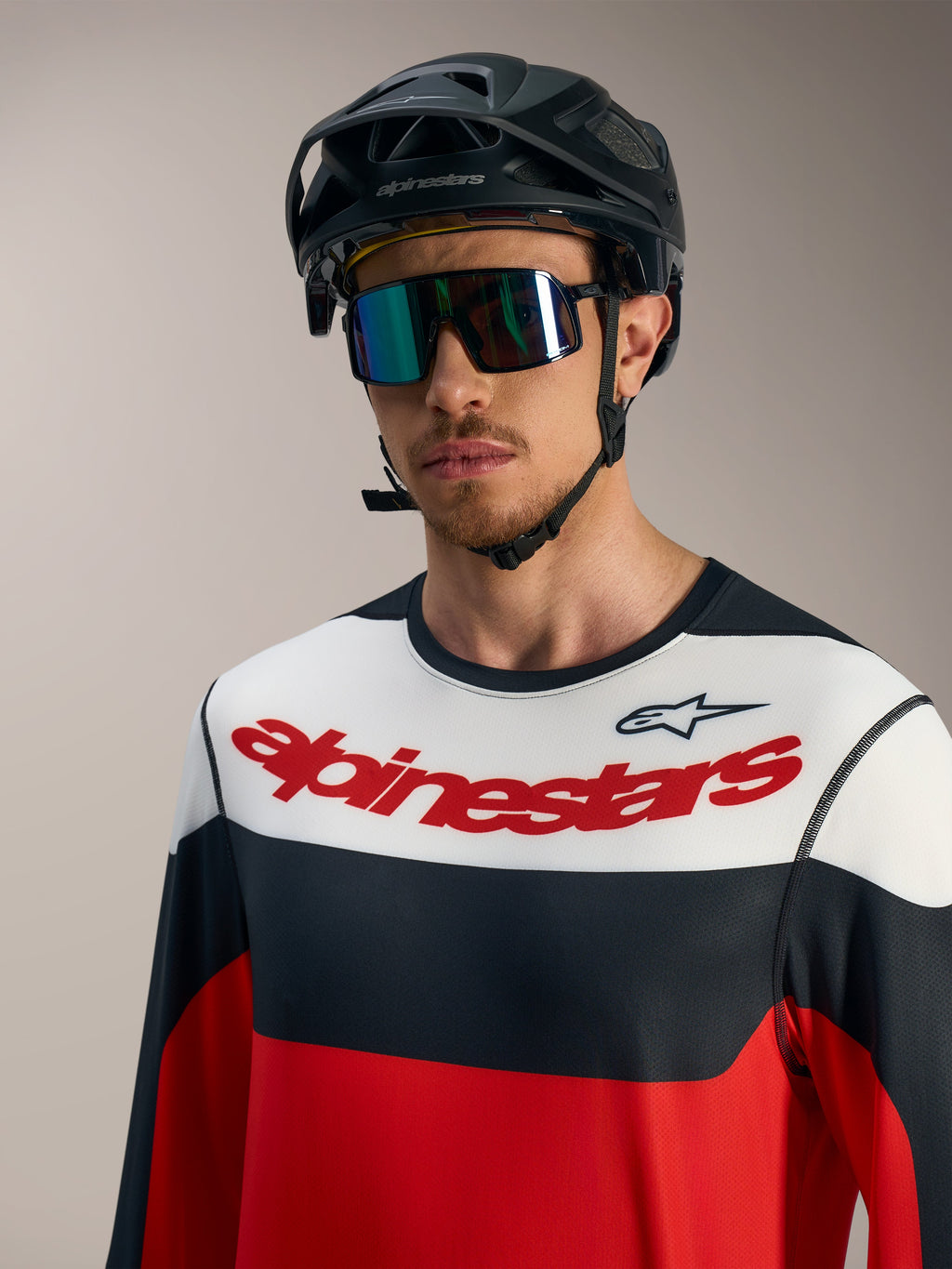 Maglia A-Dura Race rossa, nera e bianca a maniche lunghe con logo, abbinata a casco MTB nero e occhiali.
