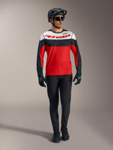 Maglia Alpinestars A-Dura Race rossa a maniche lunghe con pannelli bianchi e neri, pantaloni MTB e attrezzatura da gara.