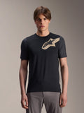 Modello che indossa la maglia Alpinestars A-Dura Lipan a maniche corte, maglia da MTB nera con logo a stella beige e maniche grigio scuro, abbinata a pantaloni da ciclismo grigi, abbigliamento tecnico casual