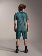 Maglia Alpinestars A-Dura Lipan a maniche corte in Silver Pine, vista posteriore che mostra i pannelli in jacquard sulle spalle e l'orlo posteriore allungato, indossata con pantaloncini da mountain bike verde scuro coordinati e calzature nere.