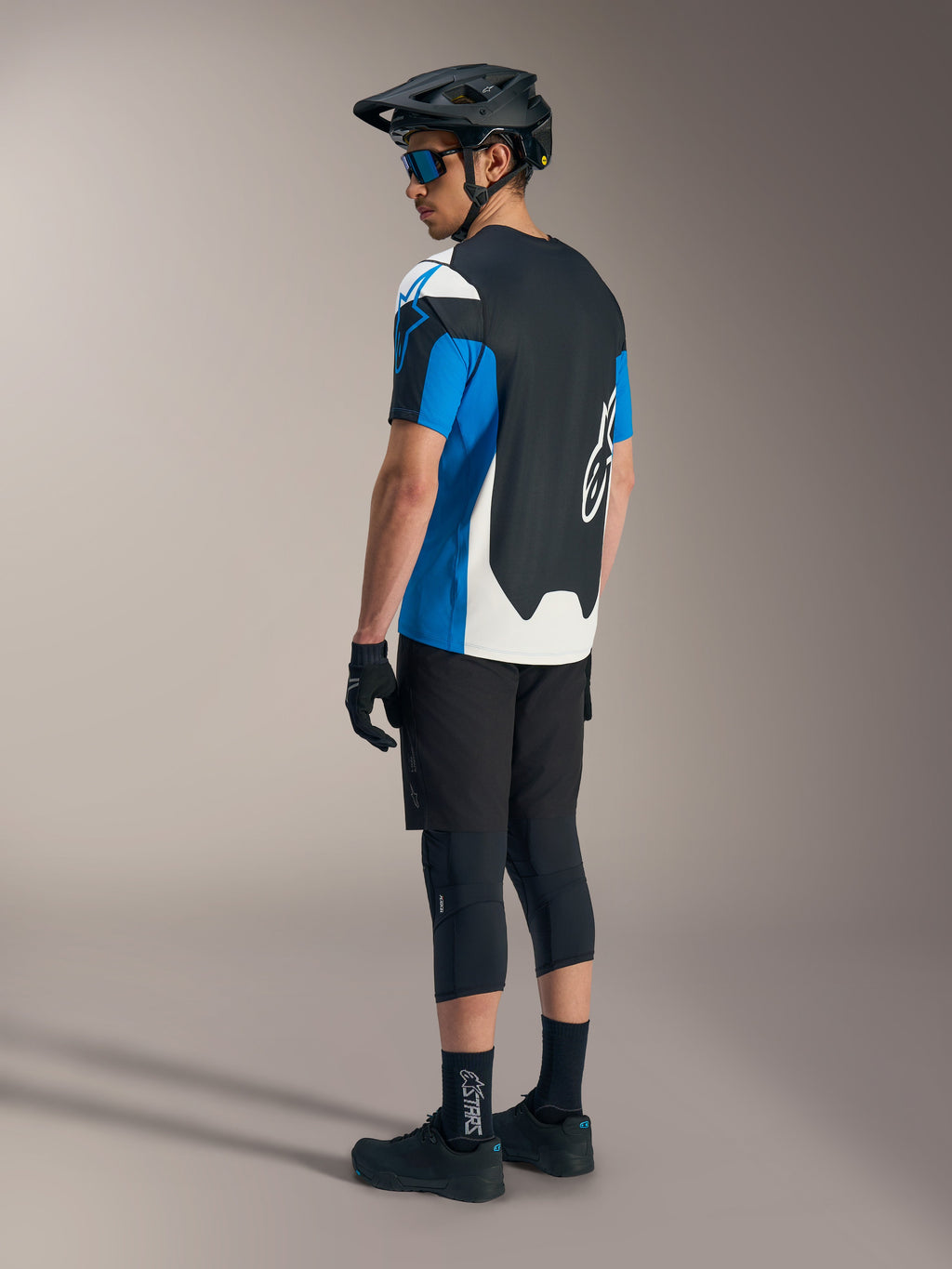 Maglia Alpinestars A-Dura Race SS blu e nera, pantaloncini MTB neri, casco e protezioni da mountain bike.