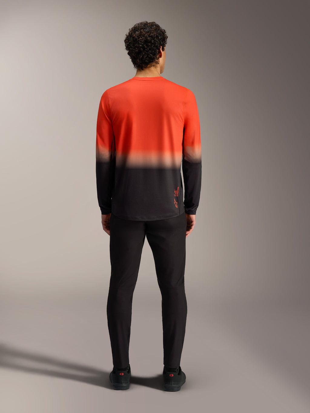 Maglia Alpinestars A-Dura ASTARS 2.0 sfumata arancione e nera, vista posteriore del modello da MTB a maniche lunghe.