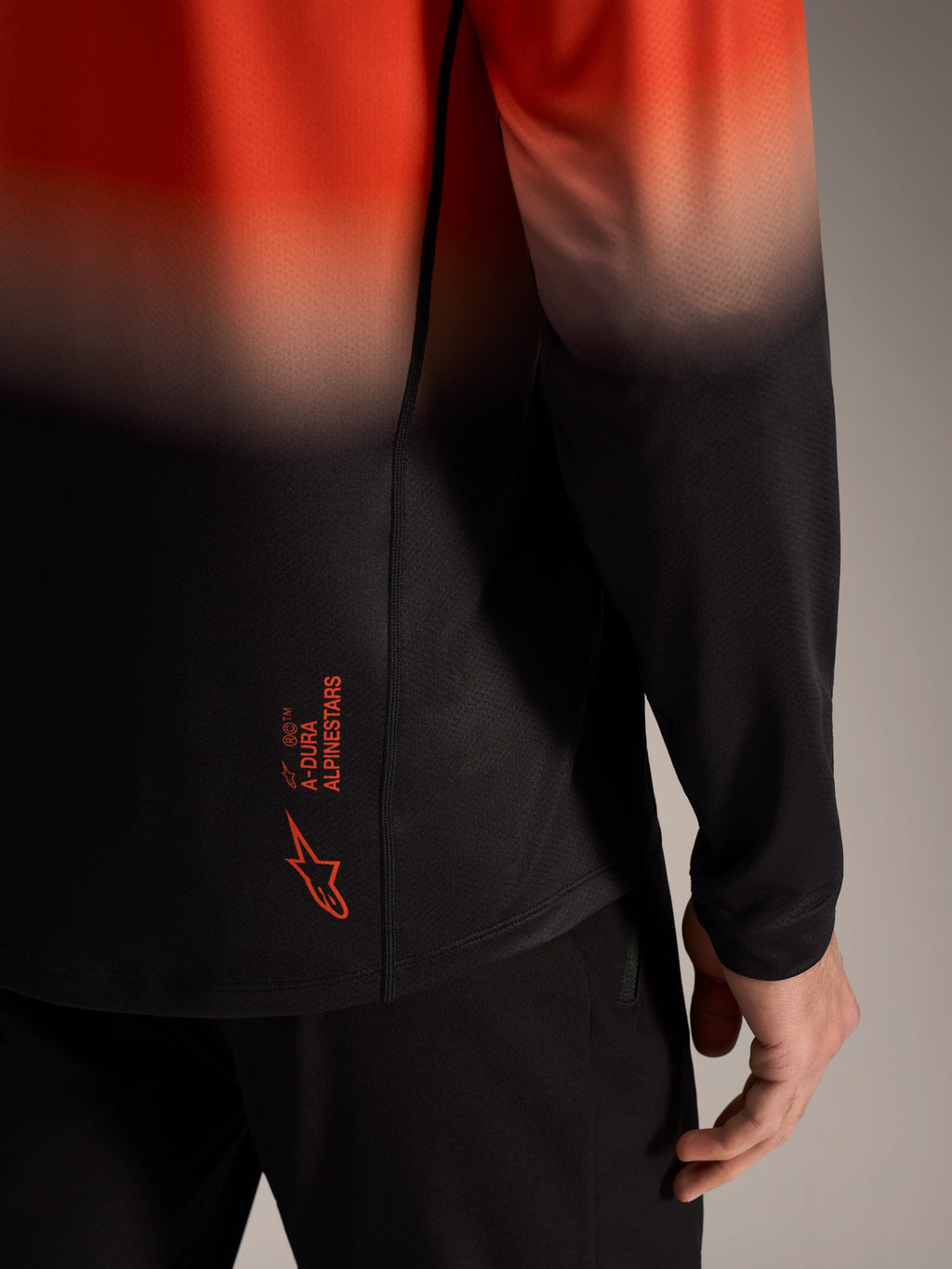 Maglia A-Dura ASTARS 2.0 arancione e nera sfumata, logo sul retro e tessuto jacquard traspirante.