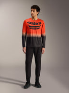 Maglia A-Dura ASTARS 2.0 arancione e nera sfumata con logo grande, abbinata a pantaloni MTB neri.