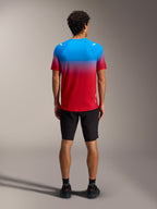 Maglia MTB A-Dura ASTARS 2.0 con sfumatura rosso e blu, maniche corte, vista posteriore con pantaloncini neri.