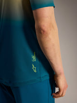 Maglia Alpinestars A-Dura ASTARS 2.0 blu-verde, dettaglio laterale con logo e marchio giallo fluo.