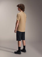 Maglia Alpinestars A-Dura Astar a maniche corte, marrone chiaro, indossata con pantaloncini neri e calze nere, tessuto jacquard traspirante, abbigliamento casual performante per mountain bike
