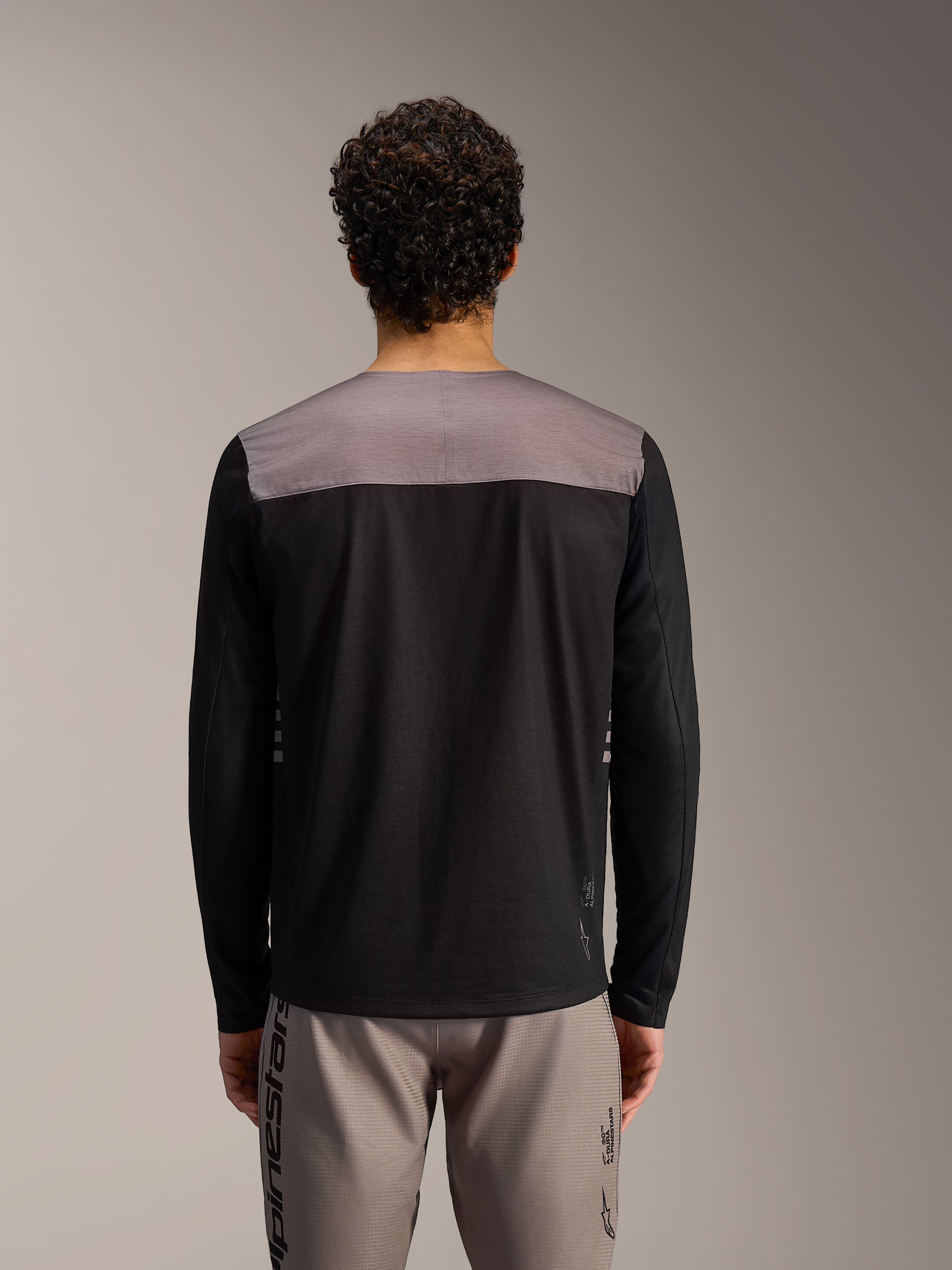 Alpinestars A-Dura Elite Maglia 2.0, maglia MTB nera a maniche lunghe con pannello grigio e vestibilità tecnica.