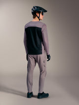 Maglia MTB A-Dura Elite 2.0 grigia a maniche lunghe con pannello nero, indossata con abbigliamento da ciclismo coordinato.