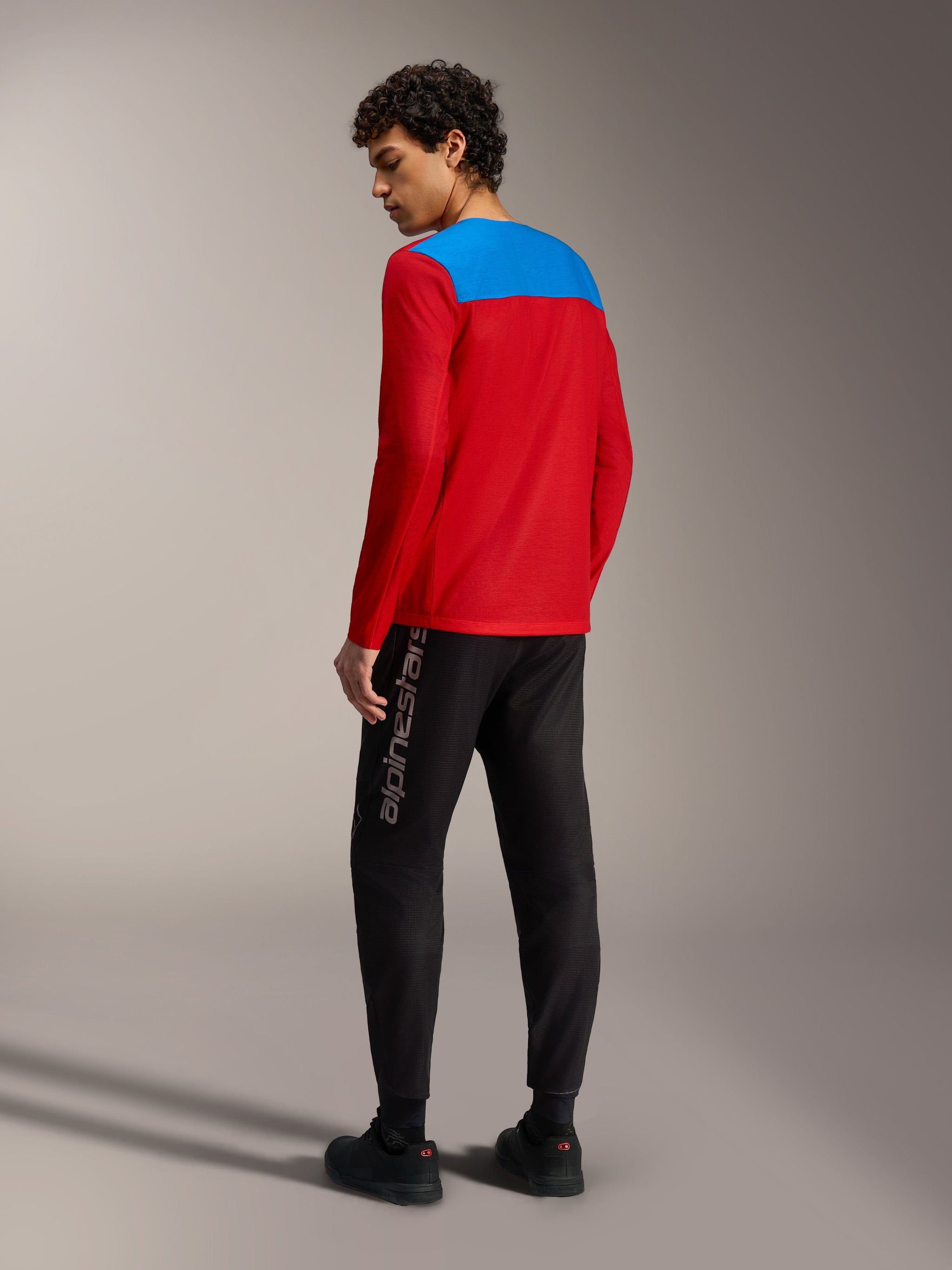 Maglia MTB Alpinestars A-Dura Elite 2.0 rossa con pannello blu, maniche lunghe e pantaloni tecnici neri.