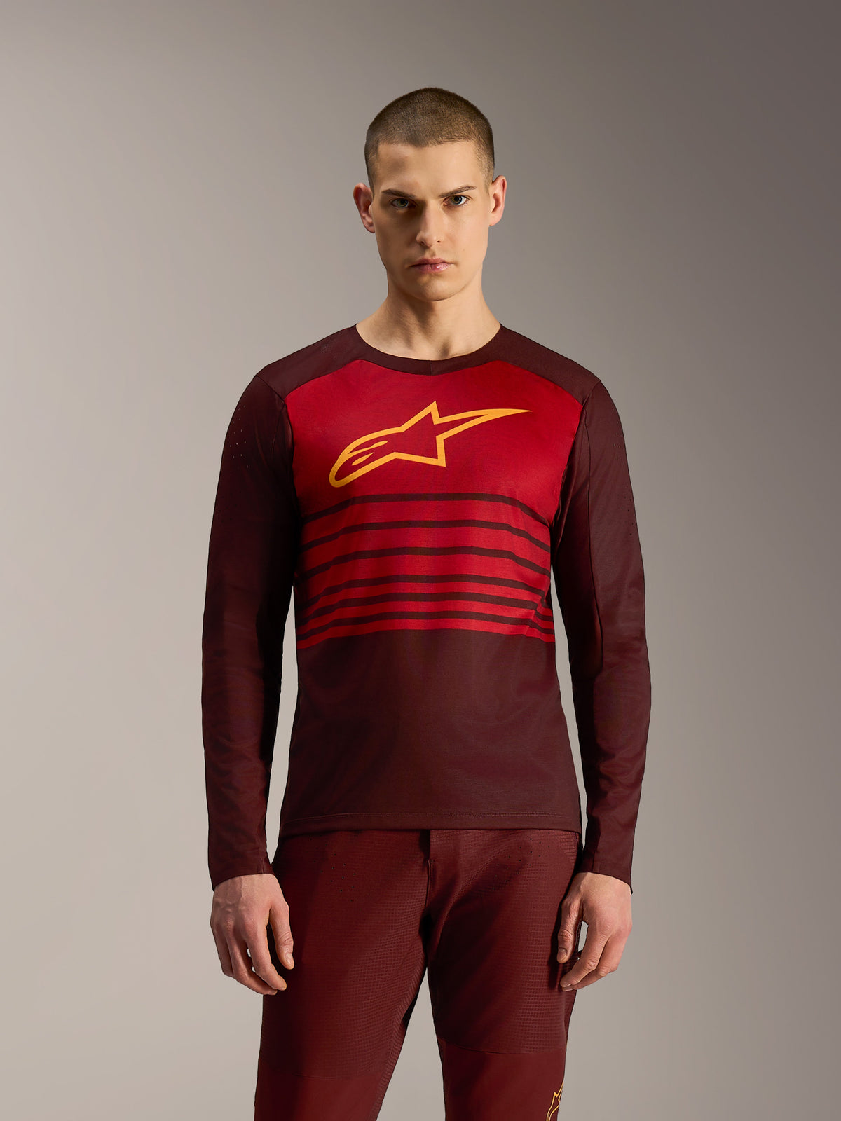 Alpinestars A-Dura Elite 2.0, maglia MTB bordeaux a maniche lunghe con strisce orizzontali e logo giallo.