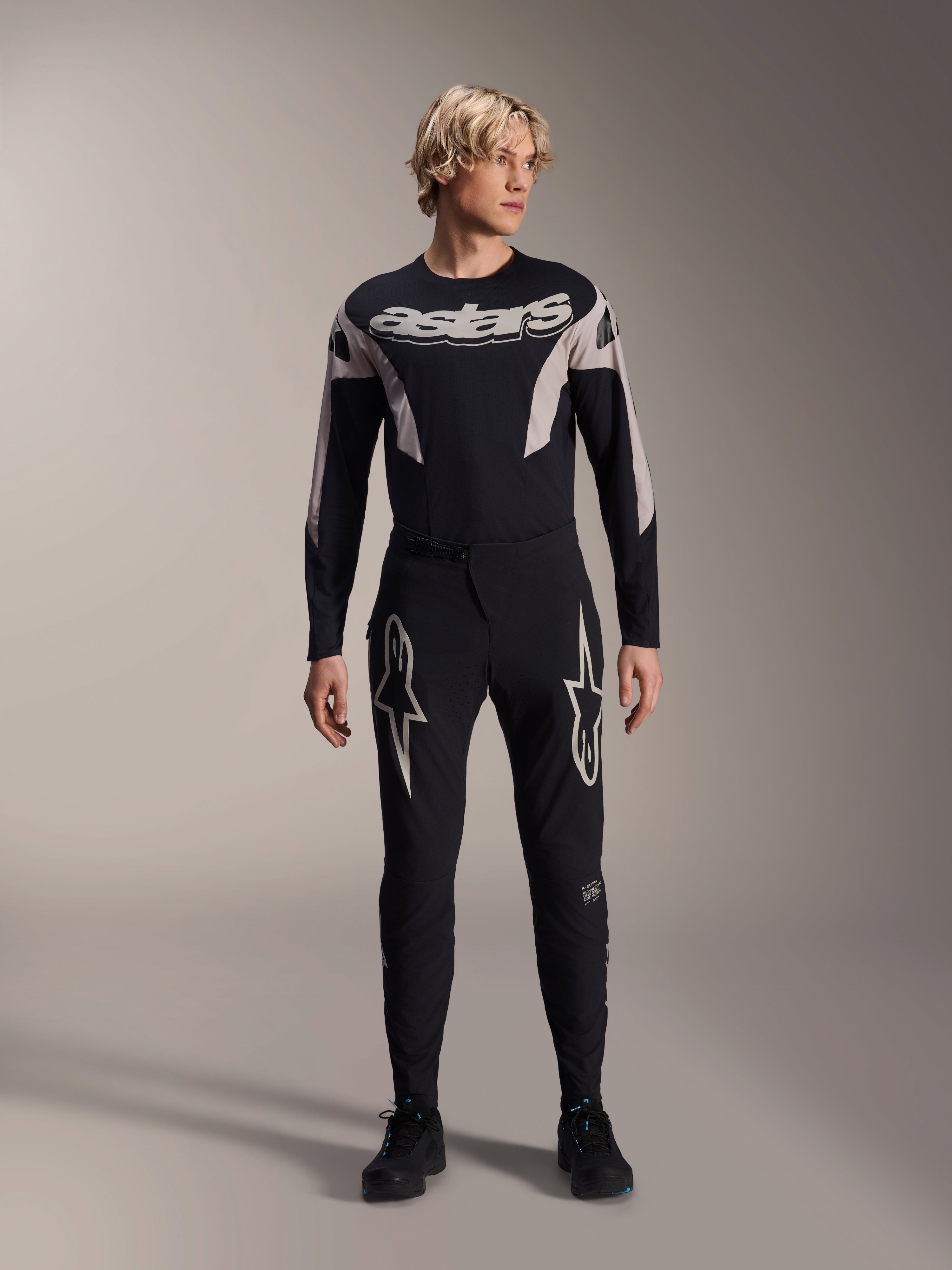Alpinestars Maglia A-Supra Melt, maglia da MTB a maniche lunghe, nera con marchio Astars bianco sul petto, indossata con pantaloni da mountain bike neri coordinati con loghi a stella, abbigliamento tecnico da ciclismo ad alte prestazioni