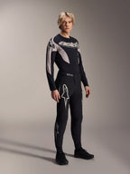 Modello che indossa la maglia Alpinestars A-Supra Melt a maniche lunghe, nera con accenti grafici grigi, logo 'astars' sul petto, abbinata a pantaloni e scarpe neri coordinati, kit da mountain bike per gare off-road