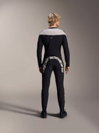 Pantaloni Alpinestars A-Supra Melt, nero, vista posteriore che mostra la grande scritta Alpinestars bianca sul carré posteriore, abbinati a una maglia a maniche lunghe coordinata e scarpe da ciclismo nere, abbigliamento da mountain bike ad alte prestazioni per il fuoristrada