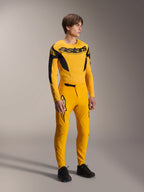 Alpinestars Limited Edition A-Supra Melt Gold Jersey, maglia MTB a maniche lunghe in giallo scuro e nero, abbinata a pantaloni gialli coordinati e scarpe nere, equipaggiamento tecnico da ciclismo off-road con grafiche d'ispirazione racing