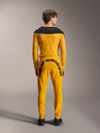 Alpinestars Maglia A-Supra Melt Gold Edizione Limitata, maglia MTB a maniche lunghe, giallo scuro, vista posteriore, con pannelli neri sulle spalle, indossata con pantaloni gialli coordinati con grande marchio nero sul retro, abbigliamento tecnico da ciclismo