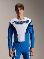Alpinestars A-Supra Melt Jersey a maniche lunghe, maglia da MTB blu e bianca con vistoso marchio astars sul petto, maniche blu scuro, indossata con pantaloni da corsa blu coordinati con loghi a stella bianchi, abbigliamento da mountain bike ad alte prestazioni