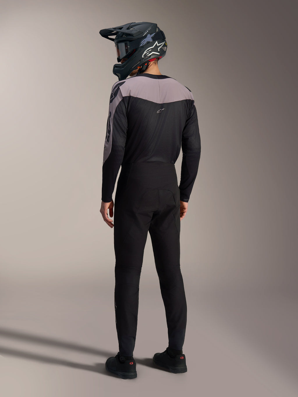 Kit MTB Alpinestars A-Supra Elite nero e grigio con maglia performance e pantaloni da gara coordinati visti dal retro.