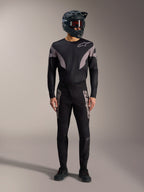 Kit MTB A-Supra Elite nero con maglia a maniche lunghe, pantaloni da gara con loghi grigi e casco integrale.