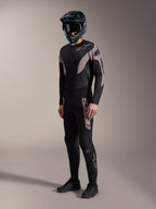 Kit MTB A-Supra Elite nero e grigio, maglia e pantaloni elasticizzati con branding Alpinestars audace.