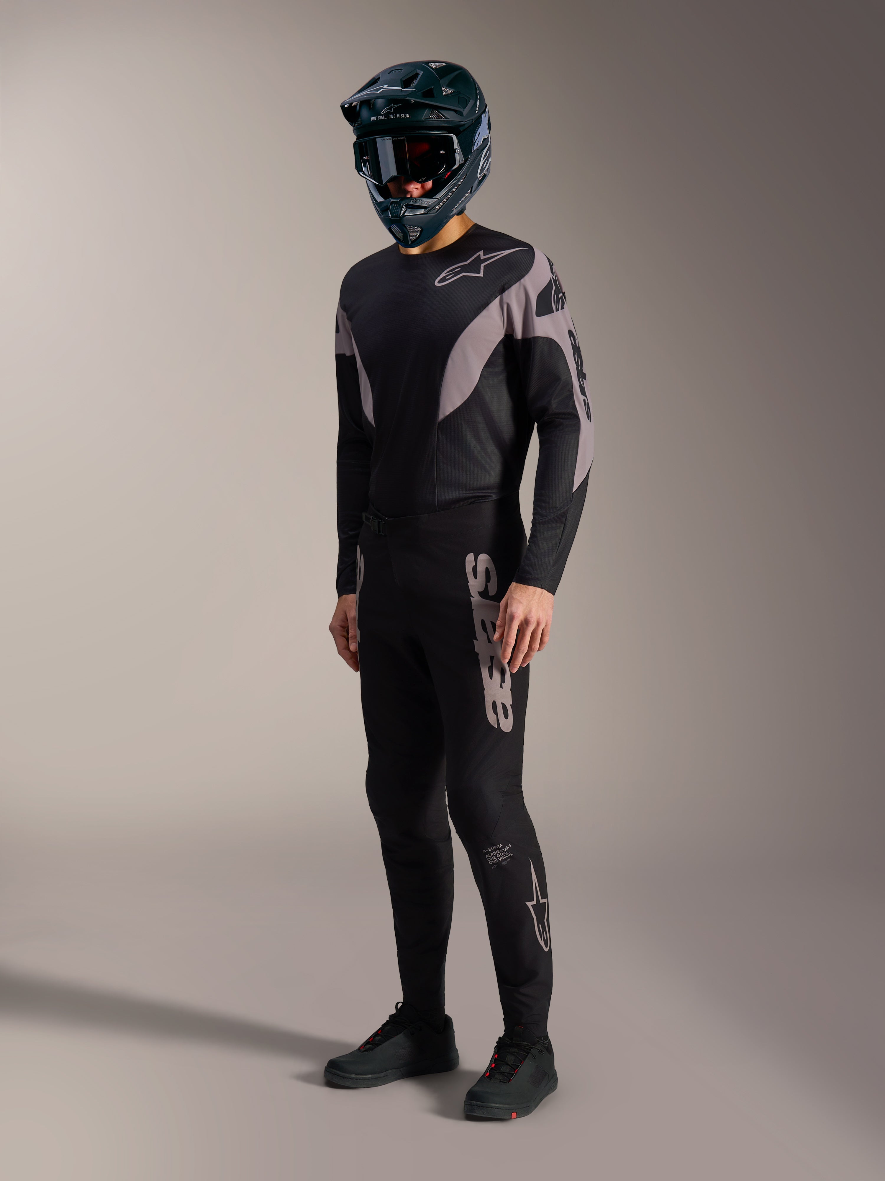 Kit MTB A-Supra Elite nero e grigio, maglia e pantaloni elasticizzati con branding Alpinestars audace.