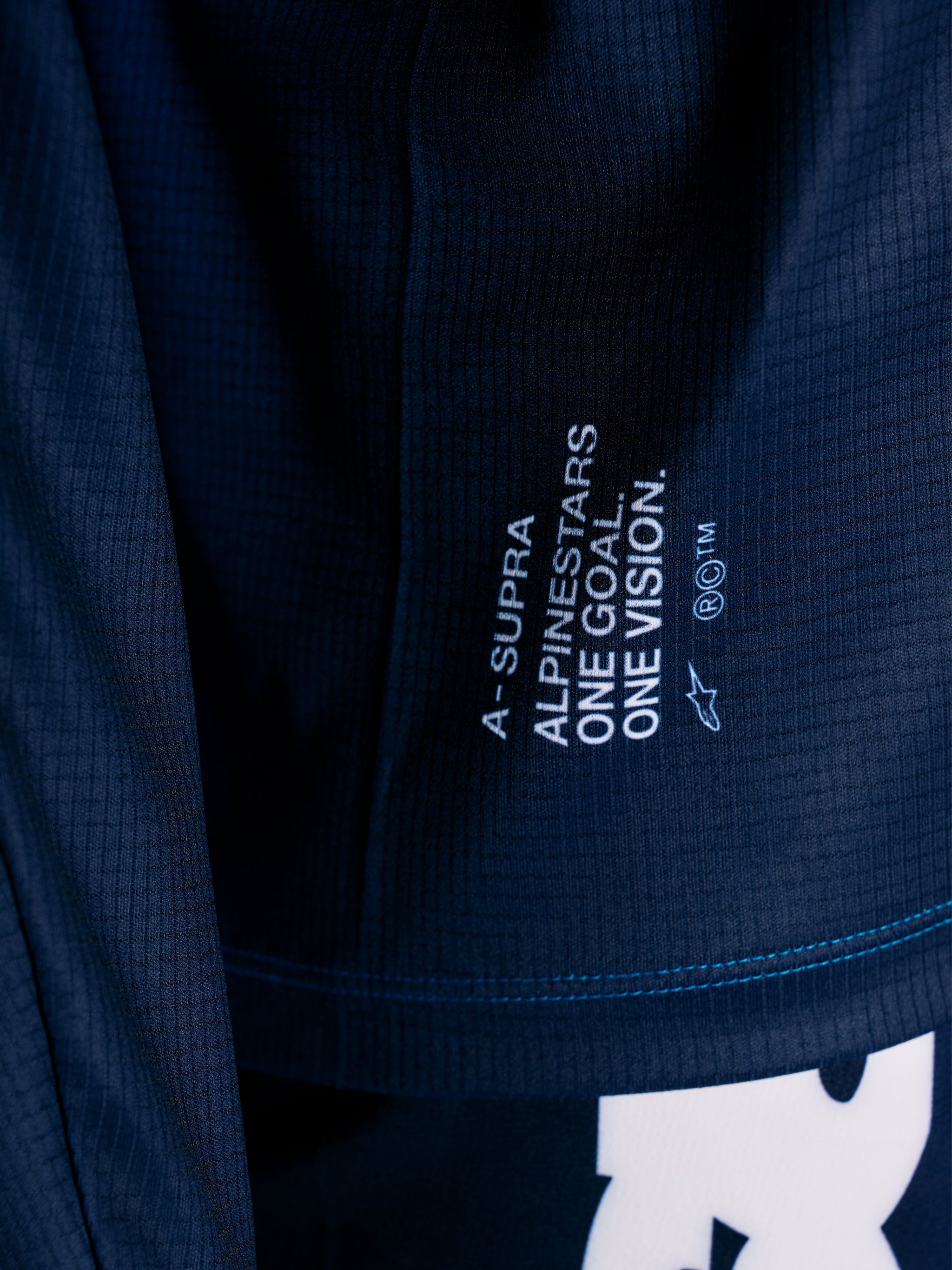 Maglia MTB Alpinestars A-Supra Elite blu, dettaglio tessuto microforato e slogan racing One Goal One Vision.