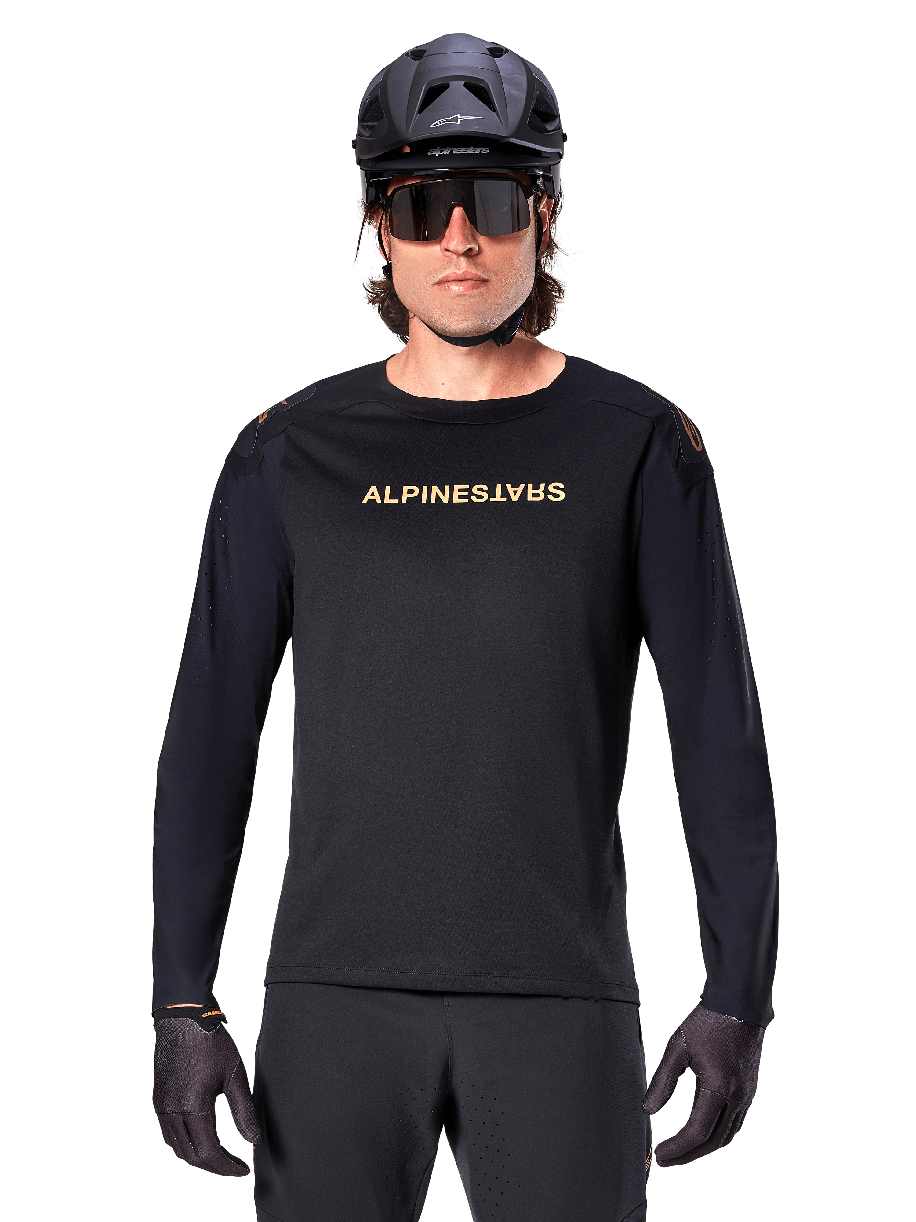 Maglia a maniche lunghe Alpinestars A-Aria Polartec Switch, nero, logo Alpinestars dorato sul petto, indossata con un casco da MTB nero, occhiali da sole scuri e guanti neri, abbigliamento professionale da trail per mountain bike
