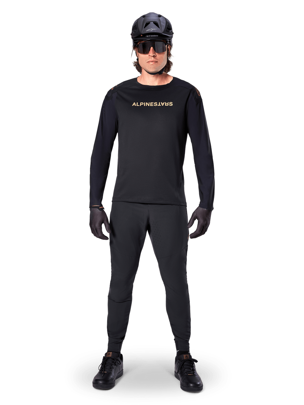Alpinestars A-Aria Polartec Switch Long Sleeve Jersey, maglia a maniche lunghe, nero, indossata da un rider con pantaloni tecnici neri coordinati, casco nero, occhiali da sole e guanti neri, attrezzatura MTB per percorsi fuoristrada