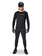Alpinestars A-Aria Polartec Switch Long Sleeve Jersey, maglia a maniche lunghe, nero, indossata da un rider con pantaloni tecnici neri coordinati, casco nero, occhiali da sole e guanti neri, attrezzatura MTB per percorsi fuoristrada