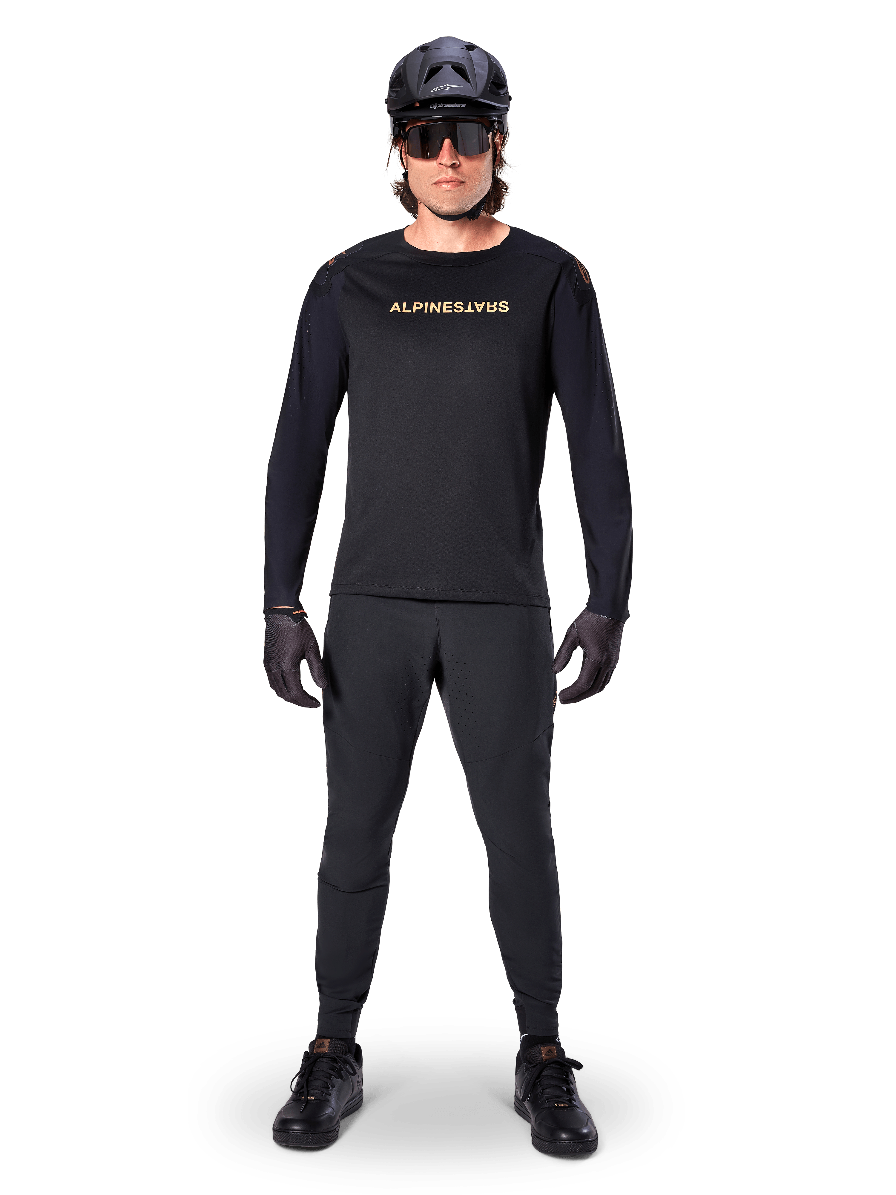 Alpinestars A-Aria Polartec Switch Long Sleeve Jersey, maglia a maniche lunghe, nero, indossata da un rider con pantaloni tecnici neri coordinati, casco nero, occhiali da sole e guanti neri, attrezzatura MTB per percorsi fuoristrada