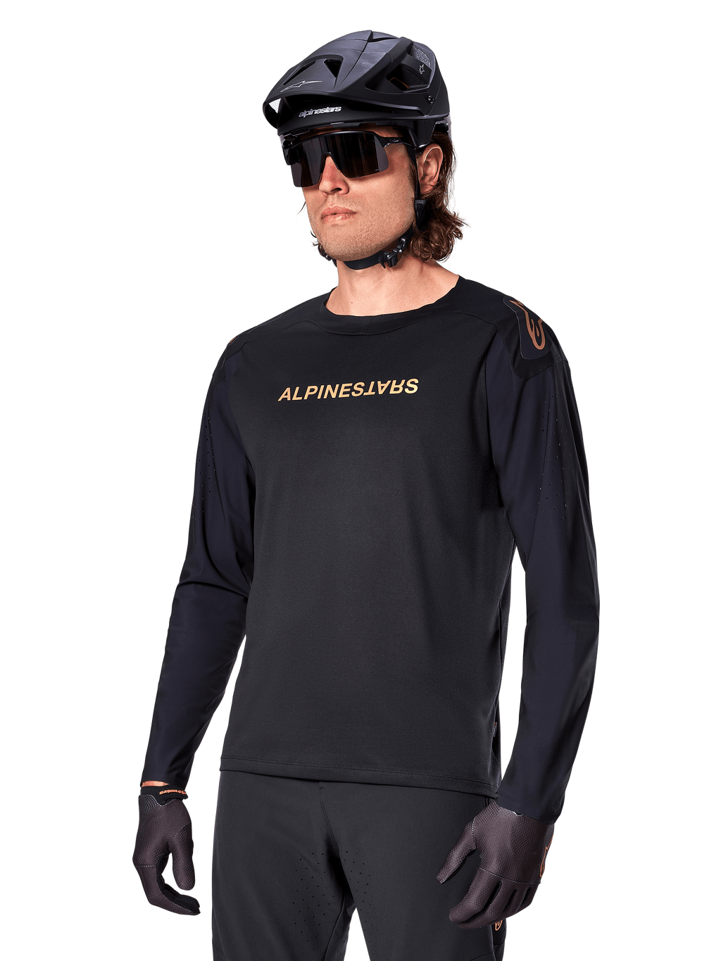 Alpinestars Maglia A-Aria Polartec Switch a maniche lunghe, nero con logo oro, abbigliamento per mountain bike MTB, indossata con casco nero e occhiali da sole, con ventilazione tagliata al laser sulle maniche e tessuto Polartec traspirante per prestazioni off-road