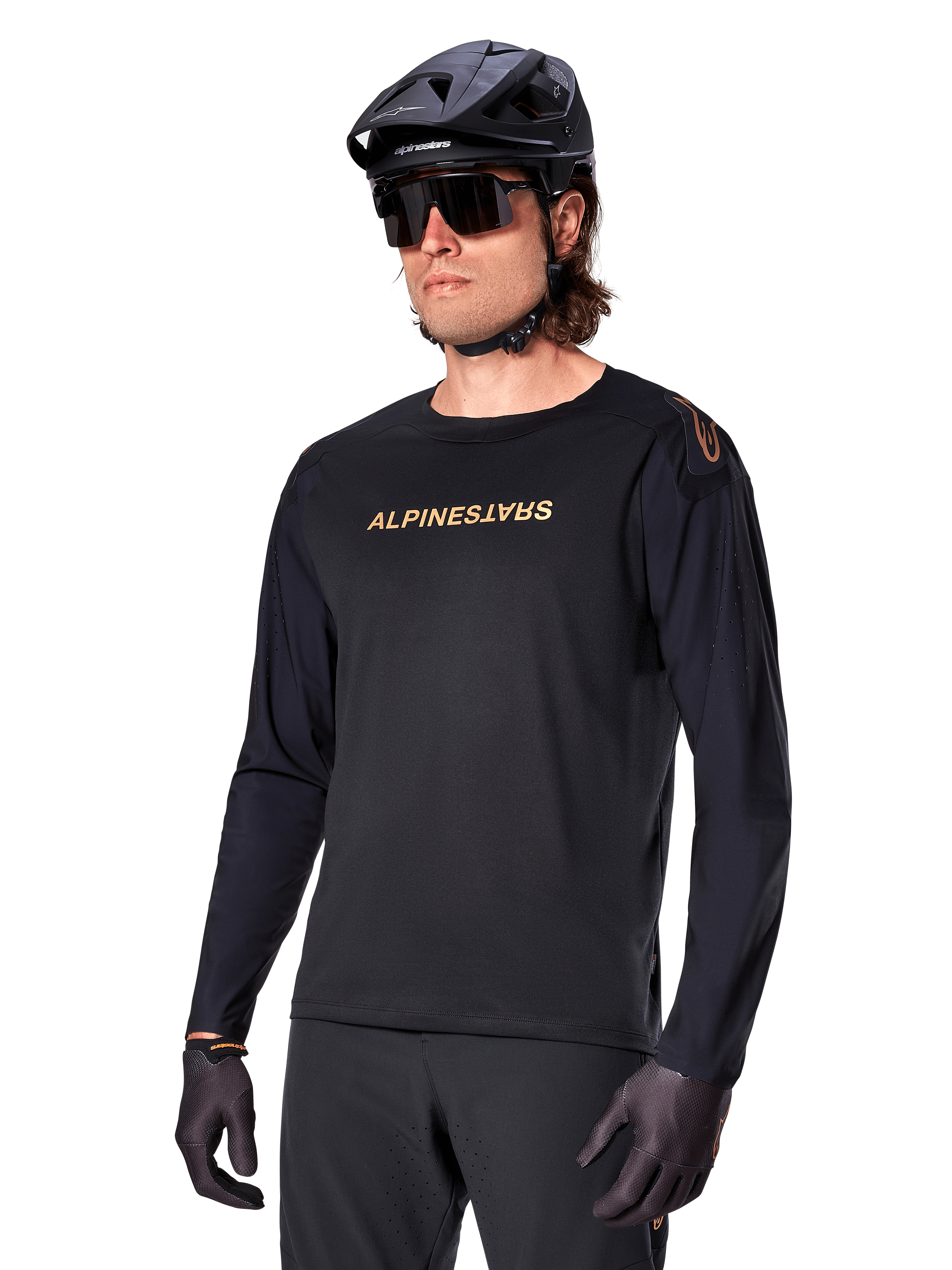 Alpinestars Maglia A-Aria Polartec Switch a maniche lunghe, nero con logo oro, abbigliamento per mountain bike MTB, indossata con casco nero e occhiali da sole, con ventilazione tagliata al laser sulle maniche e tessuto Polartec traspirante per prestazioni off-road
