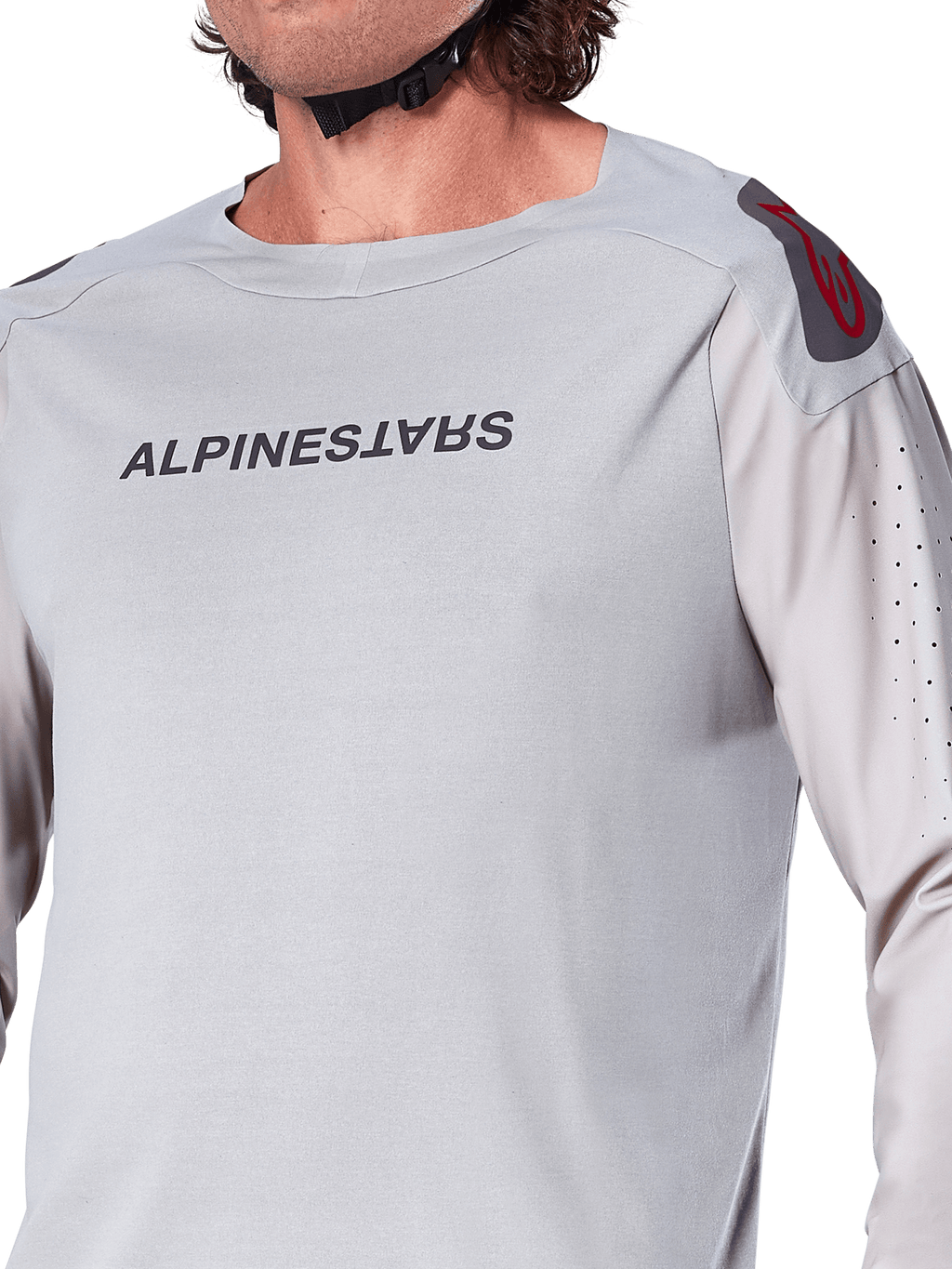 Primo piano della maglia a maniche lunghe Alpinestars A-Aria Polartec Switch in grigio chiaro, con marchio Alpinestars sul petto, logo rosso sulla spalla e maniche traforate al laser per la ventilazione, abbigliamento premium per mountain bike.