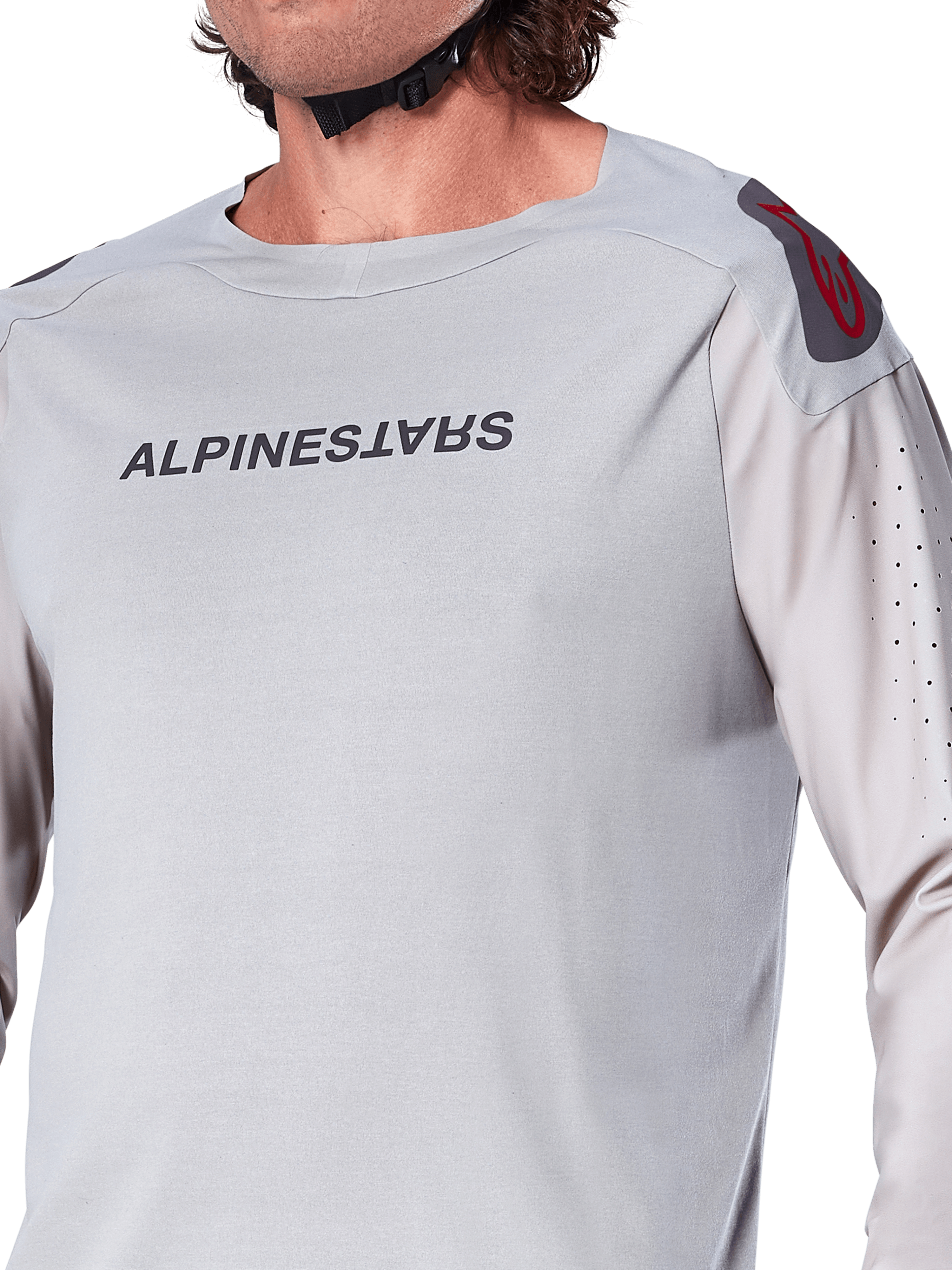 Primo piano della maglia a maniche lunghe Alpinestars A-Aria Polartec Switch in grigio chiaro, con marchio Alpinestars sul petto, logo rosso sulla spalla e maniche traforate al laser per la ventilazione, abbigliamento premium per mountain bike.