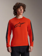 Alpinestars A-Dura Insert Astar Jersey - Long Sleeve, maglia da MTB a maniche lunghe, arancione con logo stella nero e inserti grigio scuro sulle maniche, indossata da un modello, abbigliamento tecnico da ciclismo