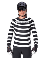 Ciclista uomo con maglia a maniche lunghe Alpinestars A-Aria Oscar, strisce orizzontali bianche e nere, logo Alpinestars riflettente sul petto, abbinata a casco MTB nero, occhiali da ciclismo e guanti tecnici