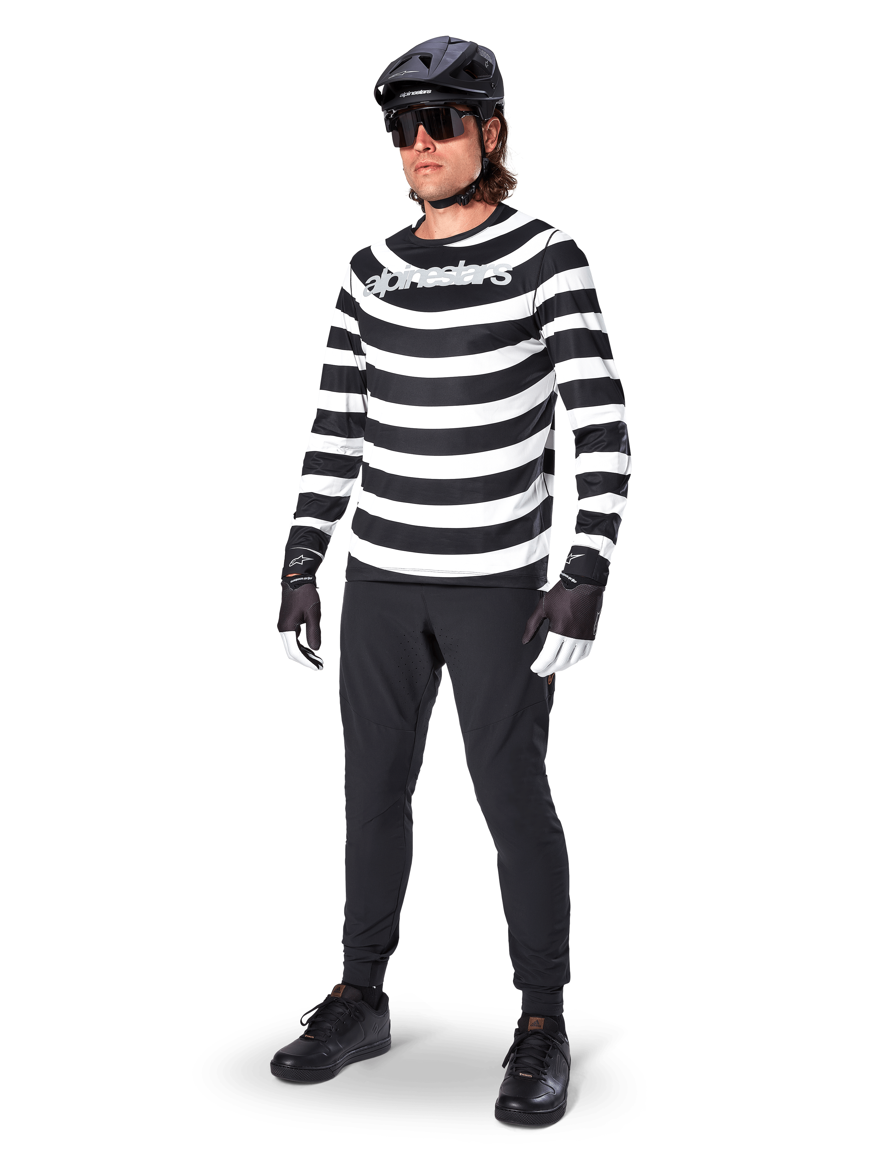 Alpinestars A-Aria Oscar Long Sleeve Jersey, maglia a maniche lunghe, nero e bianco con audaci strisce orizzontali a spirale, logo Alpinestars bianco curvo, abbigliamento MTB da performance indossato con pantaloni da ciclismo neri e casco