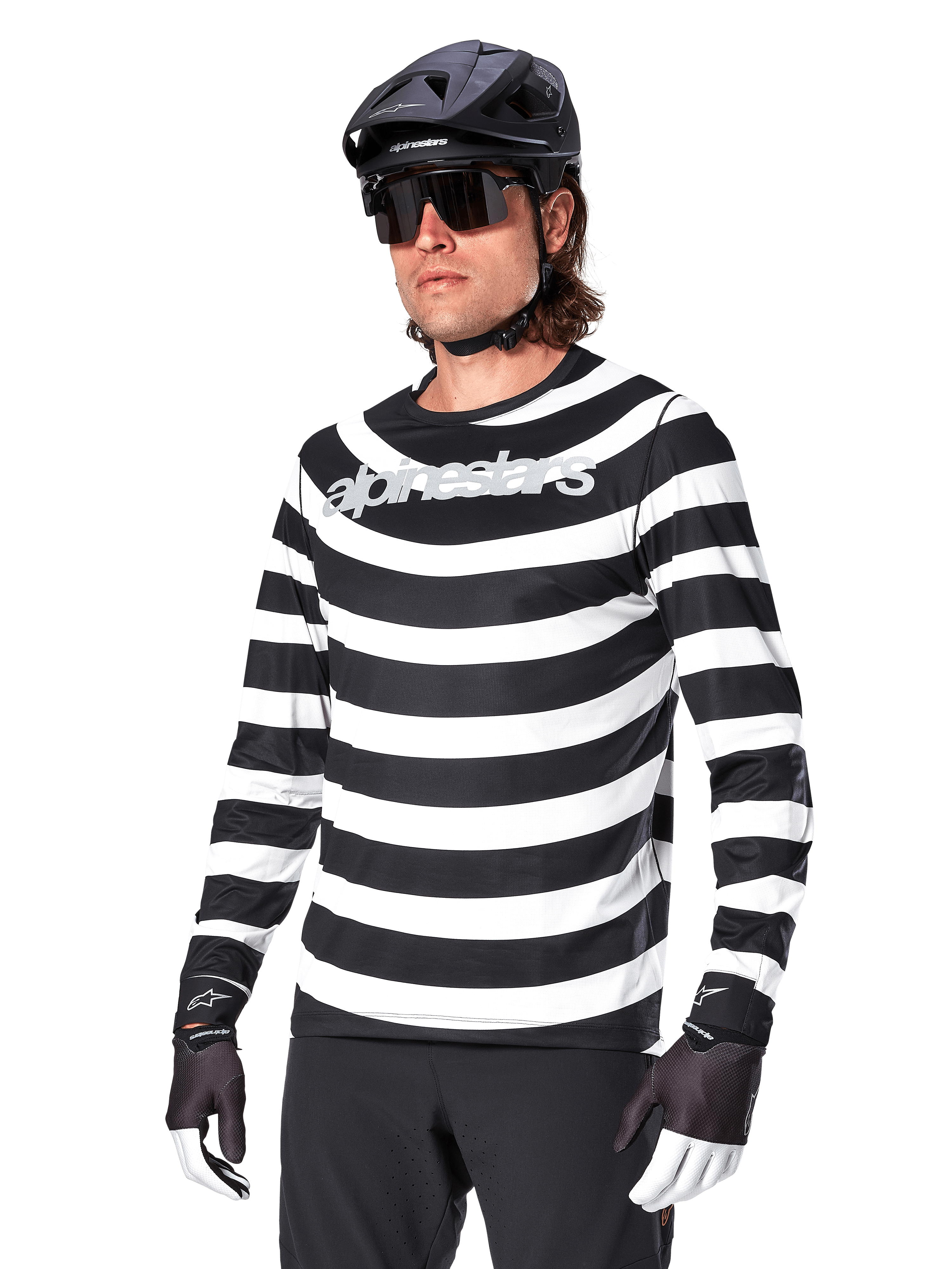 Alpinestars A-Aria Oscar Jersey a maniche lunghe, maglia da ciclismo MTB, a righe orizzontali bianche e nere, indossata con casco nero e occhiali da sole, con logo Alpinestars sul petto, abbigliamento tecnico per mountain bike
