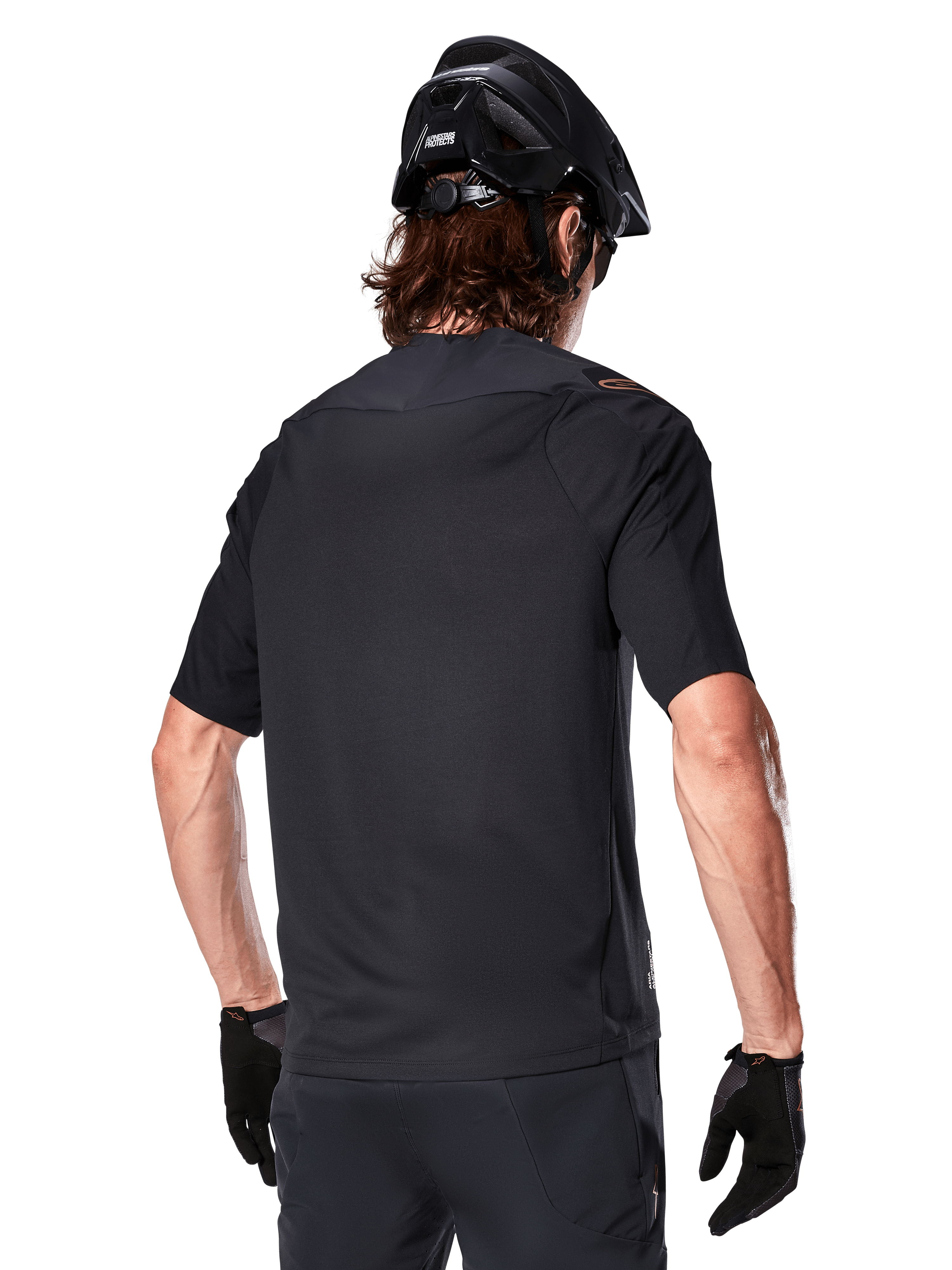 Alpinestars A-Aria Polartec Switch Short Sleeve Jersey, nero, vista posteriore su un rider con casco da mountain bike nero, pantaloncini e guanti neri coordinati, abbigliamento tecnico per mountain bike