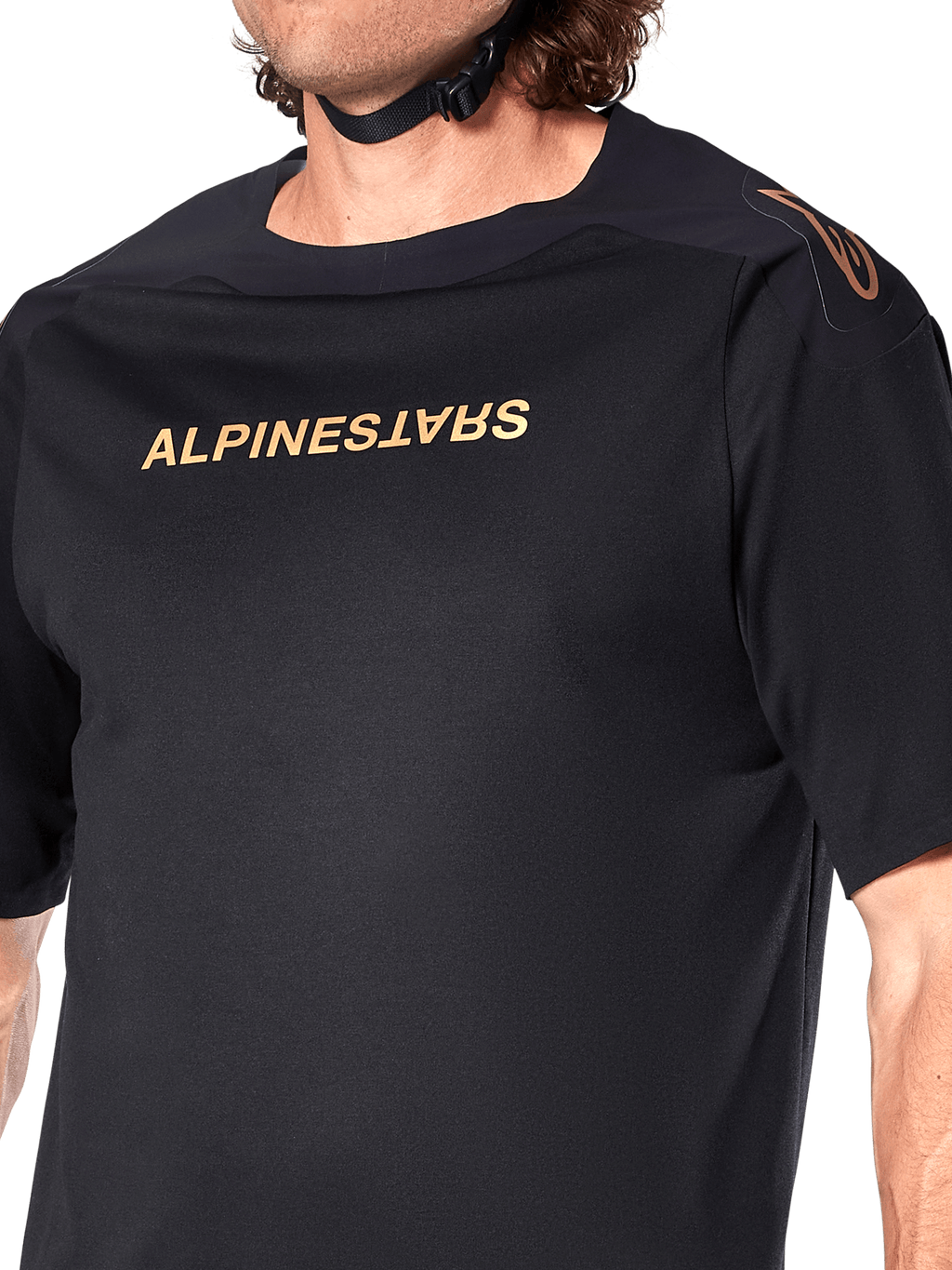 Alpinestars A-Aria Polartec Switch Jersey, maglia MTB a maniche corte, nero, scritta Alpinestars dorata sul petto e logo sulla spalla, primo piano del busto che mette in risalto il tessuto tecnico e la vestibilità performante