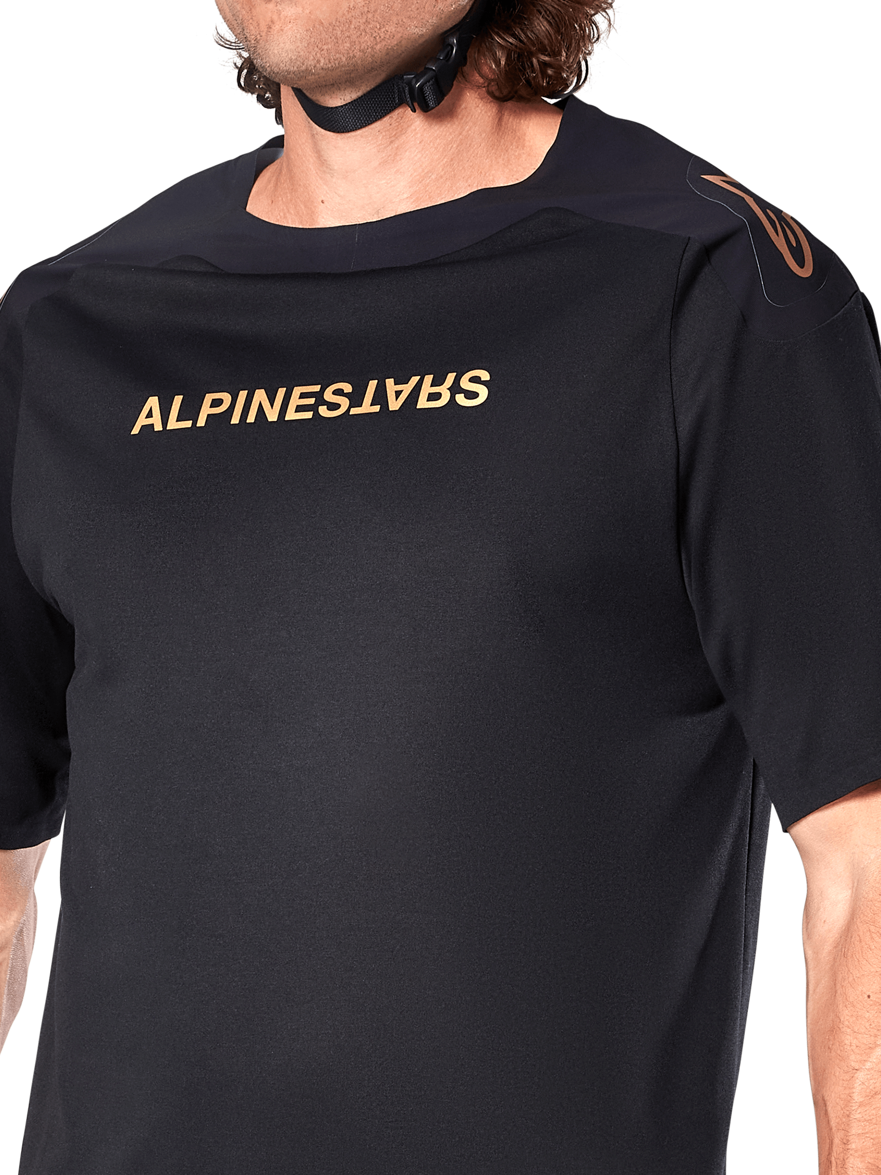 Alpinestars A-Aria Polartec Switch Jersey, maglia MTB a maniche corte, nero, scritta Alpinestars dorata sul petto e logo sulla spalla, primo piano del busto che mette in risalto il tessuto tecnico e la vestibilità performante