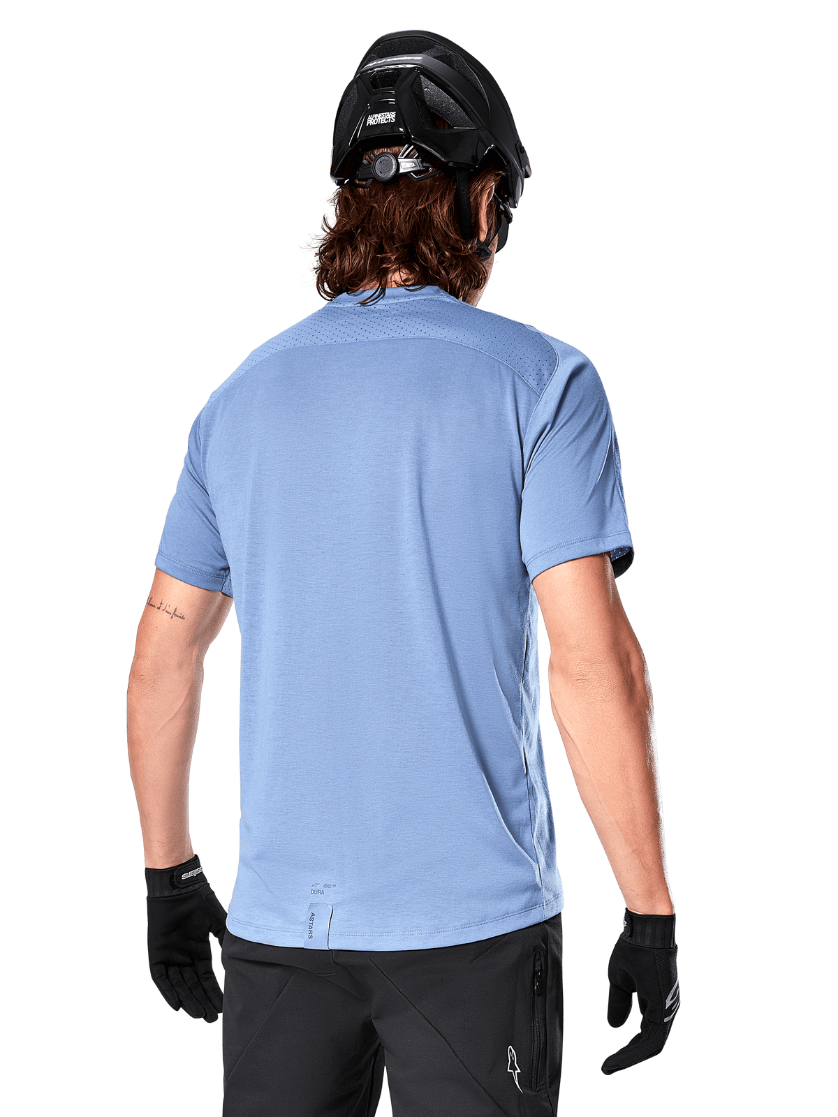 Maglia a maniche corte Alpinestars A-Dura Dri Astar, maglia MTB, Blu Infinity, vista posteriore con pannelli di ventilazione in mesh sulle spalle e coda più lunga, indossata con casco da MTB e guanti neri, abbigliamento tecnico da ciclismo
