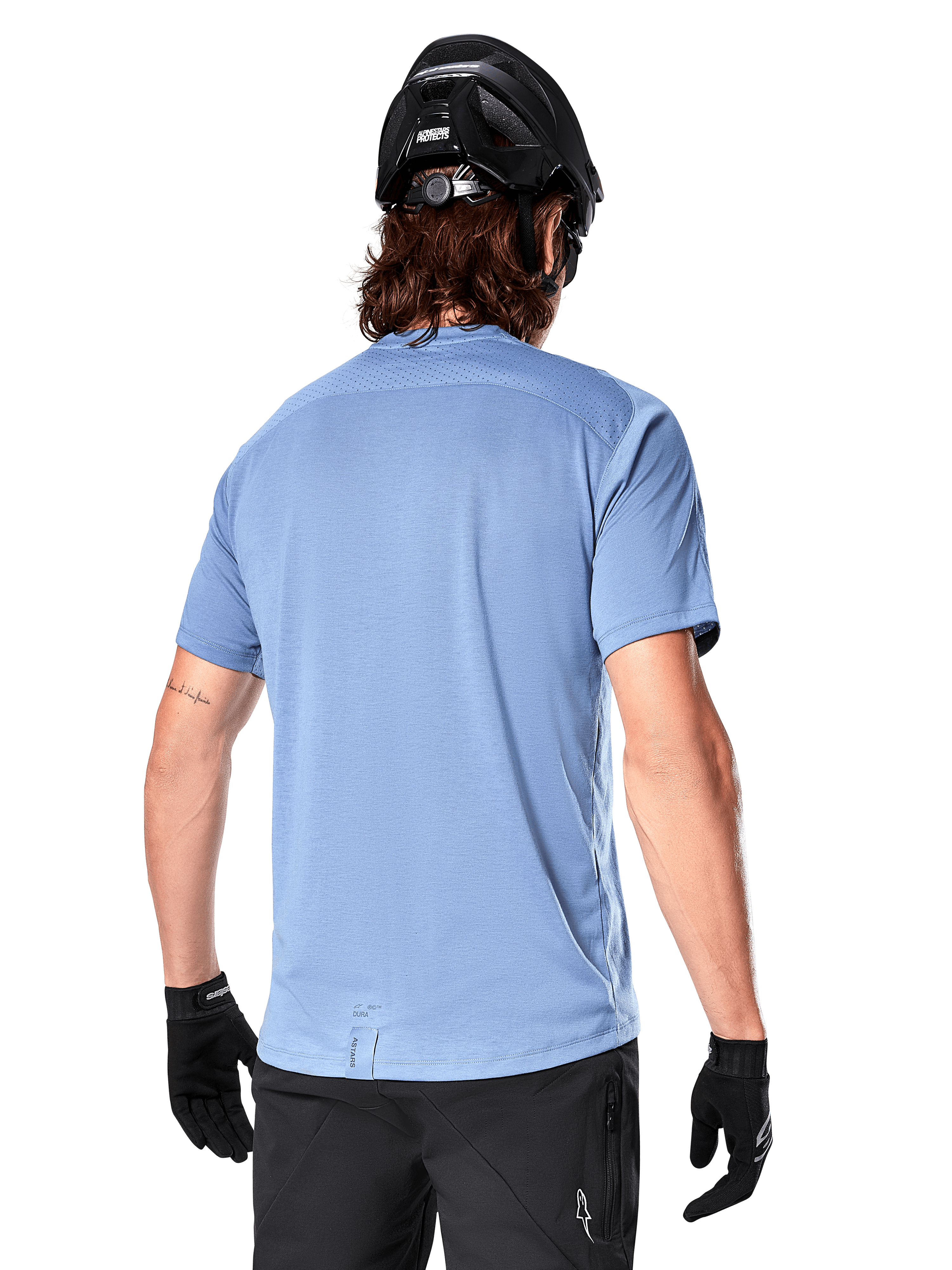 Maglia a maniche corte Alpinestars A-Dura Dri Astar, maglia MTB, Blu Infinity, vista posteriore con pannelli di ventilazione in mesh sulle spalle e coda più lunga, indossata con casco da MTB e guanti neri, abbigliamento tecnico da ciclismo