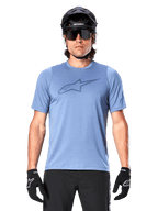 Mountain biker uomo con maglia a maniche corte Alpinestars A-Dura Dri Astar in Infinity Blue, caratterizzata da un logo discreto sul petto e pannelli in mesh, abbinata a casco nero, occhiali da sole e guanti neri per un completo tecnico da ciclismo.