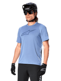 Alpinestars A-Dura Dri Astar Jersey a maniche corte, Infinity Blue, maglia da mountain bike con ventilazione in mesh sulle maniche e grande logo sul petto, indossata con casco nero, occhiali da sole e guanti, abbigliamento tecnico per prestazioni MTB