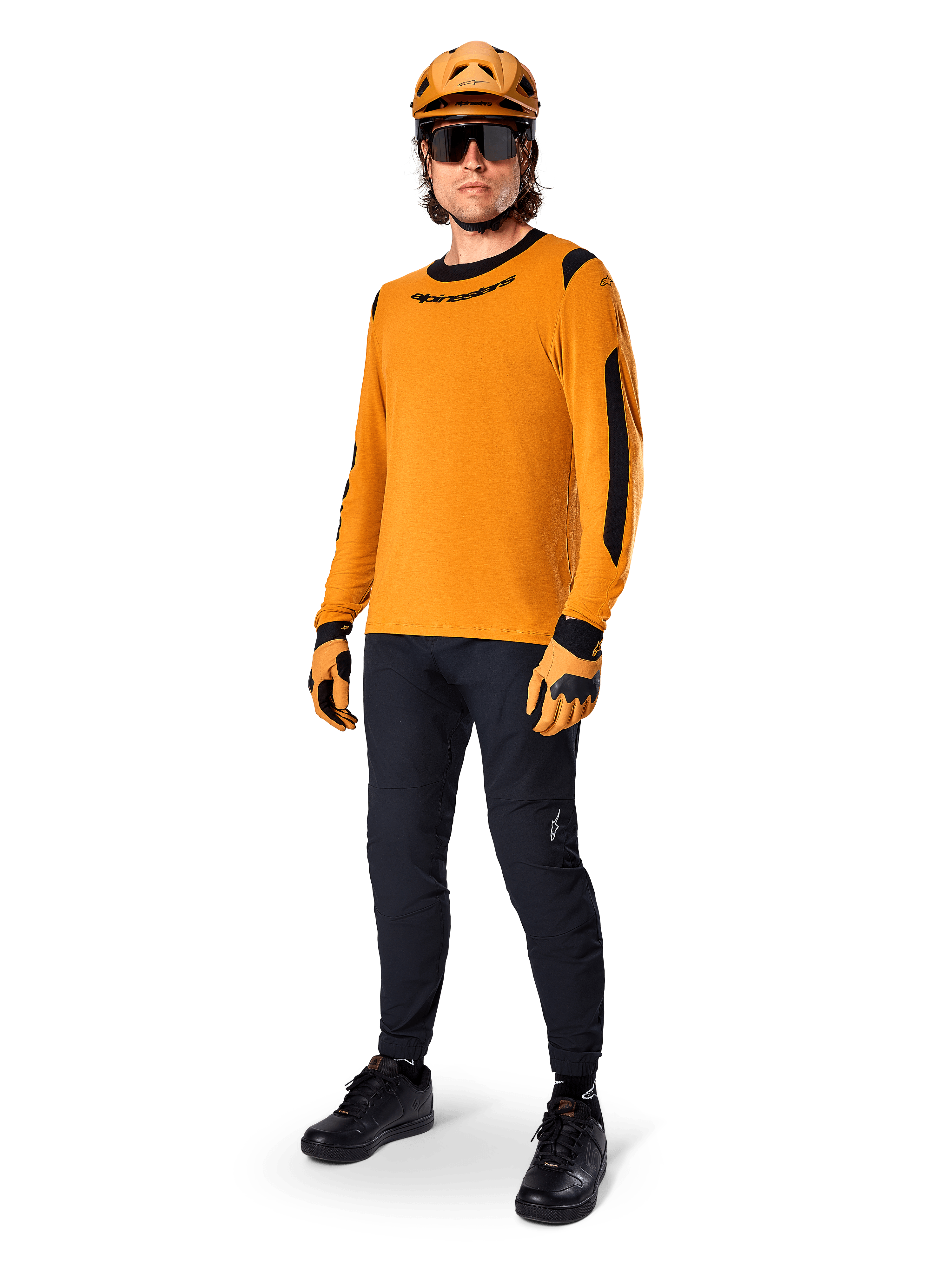 Alpinestars A-Dura Dri Wool Jersey - Manica Lunga, Dark Gold, indossata con casco arancione coordinato, pantaloni da MTB neri e guanti gialli e neri, outfit completo da ciclismo per trail fuoristrada