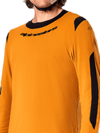 Maglia a maniche lunghe Alpinestars A-Dura Dri Wool, Dark Gold, primo piano del colletto a girocollo nero con logo e dei pannelli di ventilazione in rete nera su spalle e braccia, abbigliamento da mountain bike ad alte prestazioni