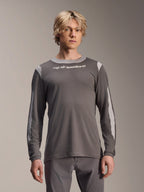 Alpinestars A-Dura Dri Wool Jersey a maniche lunghe, grigio scuro, indossata da un modello, con pannelli in rete grigio chiaro su spalle e maniche, logo bianco sul petto, abbigliamento tecnico per mountain bike