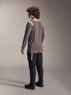 Maglia a maniche lunghe Alpinestars A-Dura Dri-Wool in grigio abbinata a pantaloni A-Dura Elite in nero, vista posteriore del modello, con logo Alpinestars bianco sulla gamba, abbigliamento tecnico da mountain bike per guida fuori strada