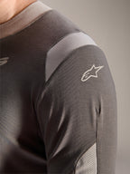 Alpinestars Maglia A-Dura Dri Wool - Manica Lunga, grigio scuro, vista dettagliata della spalla e della manica che mostra i pannelli di ventilazione in rete grigio chiaro e il logo Astars bianco sul tessuto tecnico drirelease.